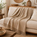 Couverture Bruyère beige foncé jetée sur un canapé clair