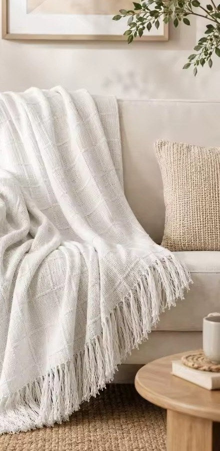 Couverture Bruyère blanche sur un canapé, franges visibles