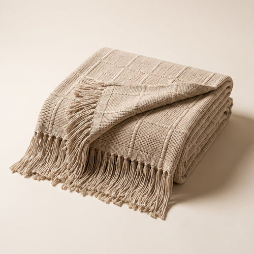 Couverture maillée respirante, coloris beige foncé, pliée sur fond papier